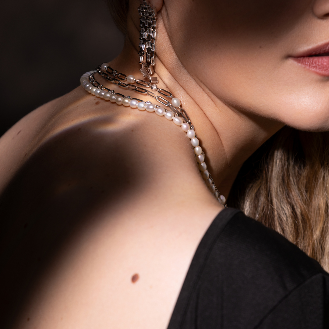 Glæsilegt hálsmen sem tekið er eftir.

Menið samanstendur af ferskvatnsperlum, silfurkeðjum og glitrandi Sirkon steinum og liggur einstaklega fallega á.&nbsp;